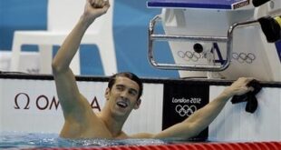 United States' Michael Phelps smiles on the podium before being presented with the gold medal in the men's 100-meter butterfly swimming final at the Aquatics Centre in the Olympic Park during the 2012 Summer Olympics in London, Friday, Aug. 3, 2012. (AP Photo/Michael Sohn)