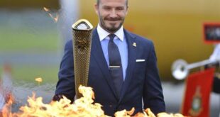 British soccer player and London 2012 Olympic Games ambassador David Beckham reacts after lighting the Olympic torch with a cauldron after arriving at RNAS Culdrose base near Helston in Cornwall, south west England in this May 18, 2012, file photo. (REUTERS/Toby Melville/Files)
